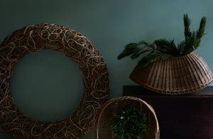 Studio Amos random woven wreath line scull and fish kettle baskets with holiday greenery.