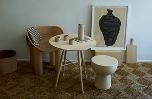 Takashi Endo white ceramic mugs and carafe on a Sawyer Made small ash round table with a Faye Toogood raw roly poly dining chair and white roly poly stool pulled up for seating.