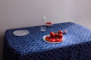 Summery table set with Italian Murano glass dinnerware on hand-printed checkered floral indigo tablecloth with. Default