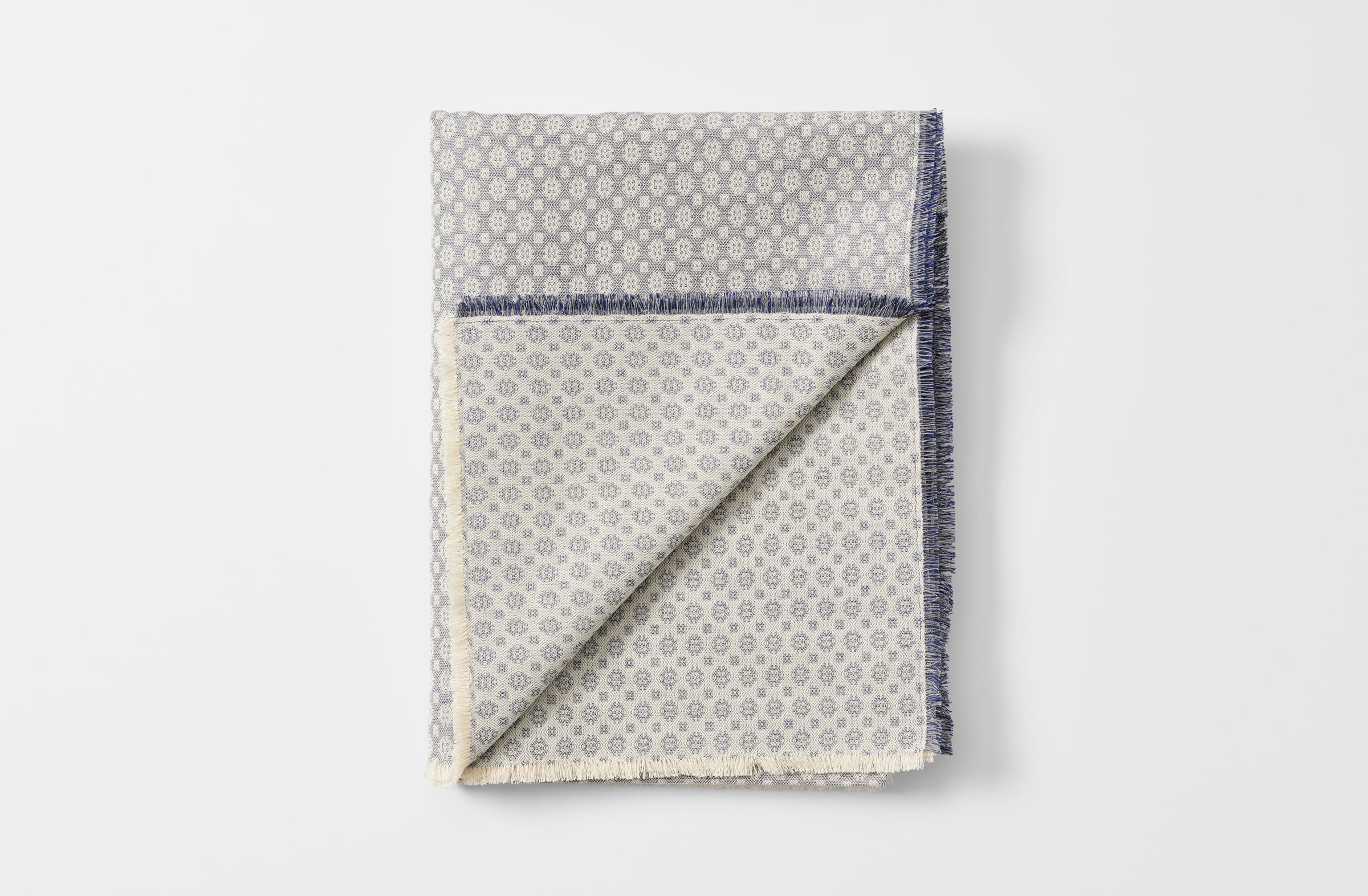 Blue diamond weave tablecloth folded with detail of reverse side