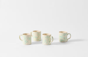 Four celadon and cream splatterware mugs.