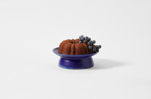 Small Christiane Perrochone blue violet cake stand with a bundt cake and grapes