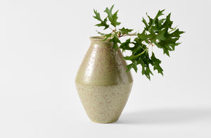 Christiane Perrochon green gray spot medium vase holding oak leaves.