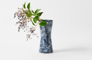 Christiane Perrochon indigo and white hourglass vase with winter berry branches.