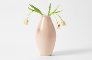Christiane Perrochon pink crystal tall vase holding pale yellow tulips.