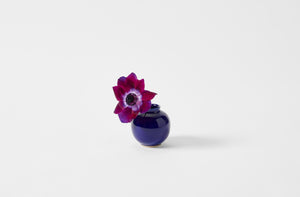 Shiny blue Christiane Perrochon petite boule vase holding purple flower