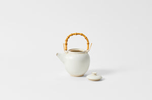 Christiane Perrochon white beige medium teapot with bamboo handle and lid off.