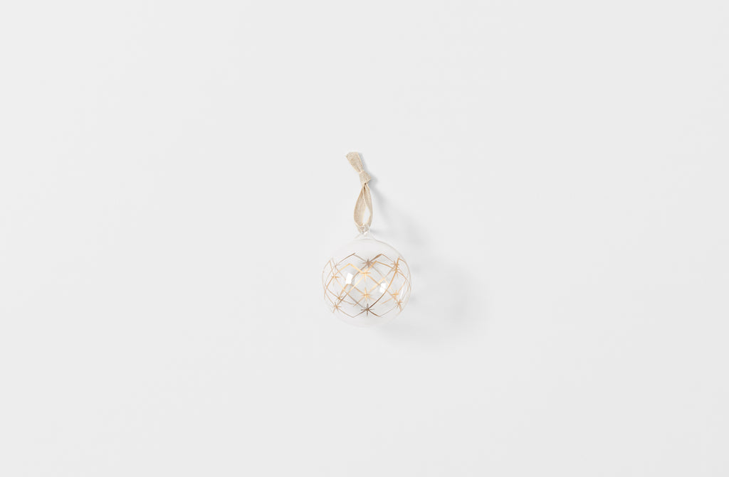 Clear glass ball ornament with gold star pattern strung with linen tape