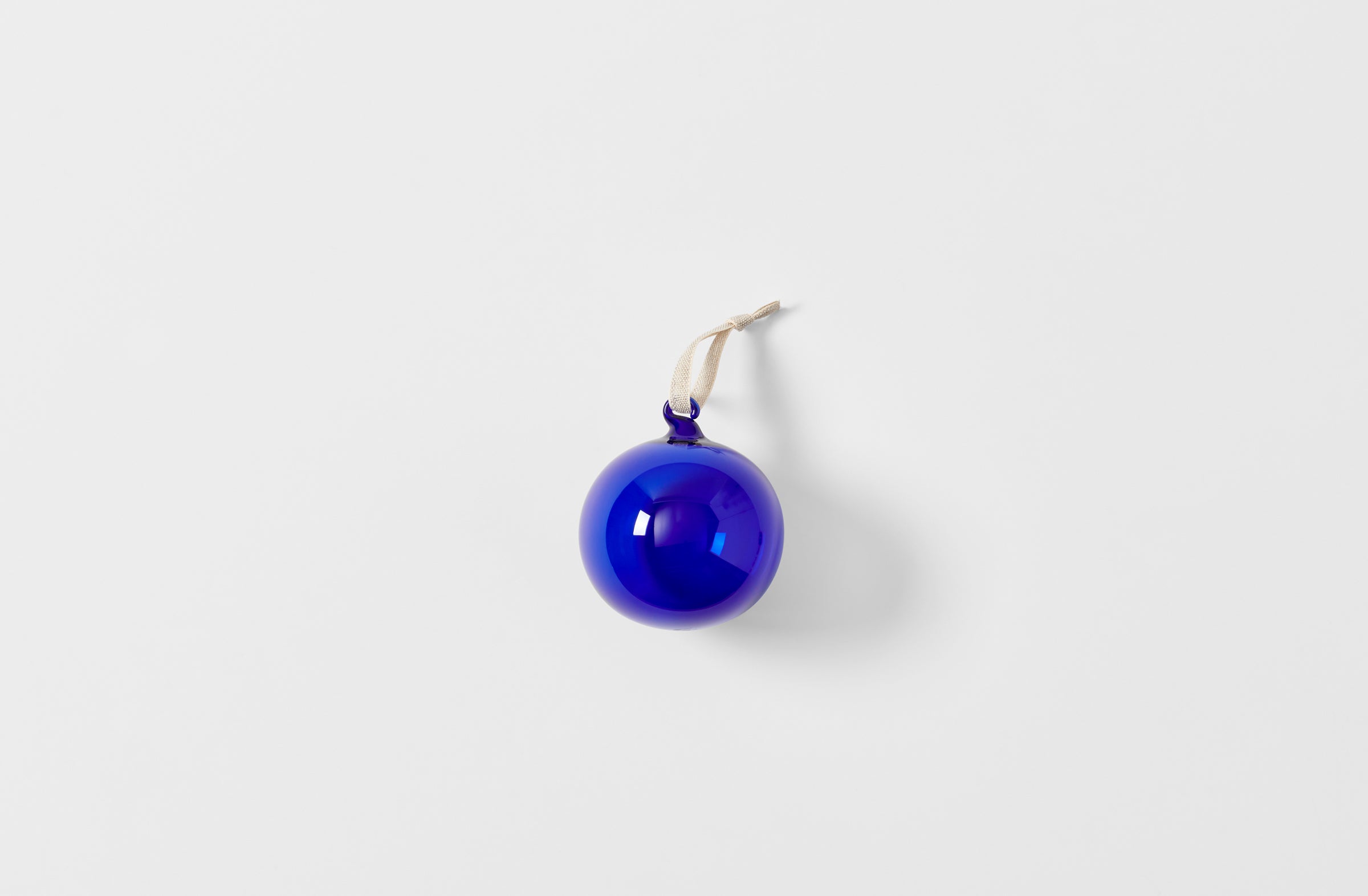 Single cobalt glass ornament strung with linen tape