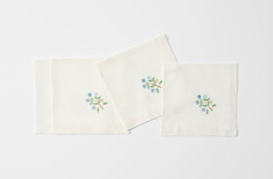 Four daisy embroidered napkins folded.