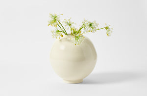 Faye Toogood cream moon vase holding white allium flowers.