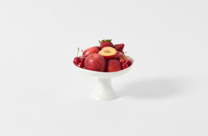 Feldspar Studio red rim fruit bowl holding red summer fruit.