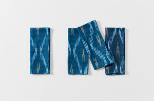 Group of four folded Gregory Parkinson faded blue triangle napkins
