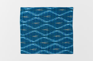 Single open Gregory Parkinson faded blue triangle napkin