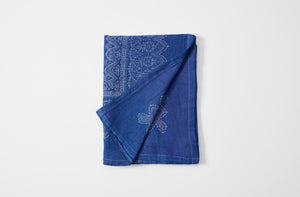Hand printed bandana border indigo linen tablecloth folded with detail of reverse.