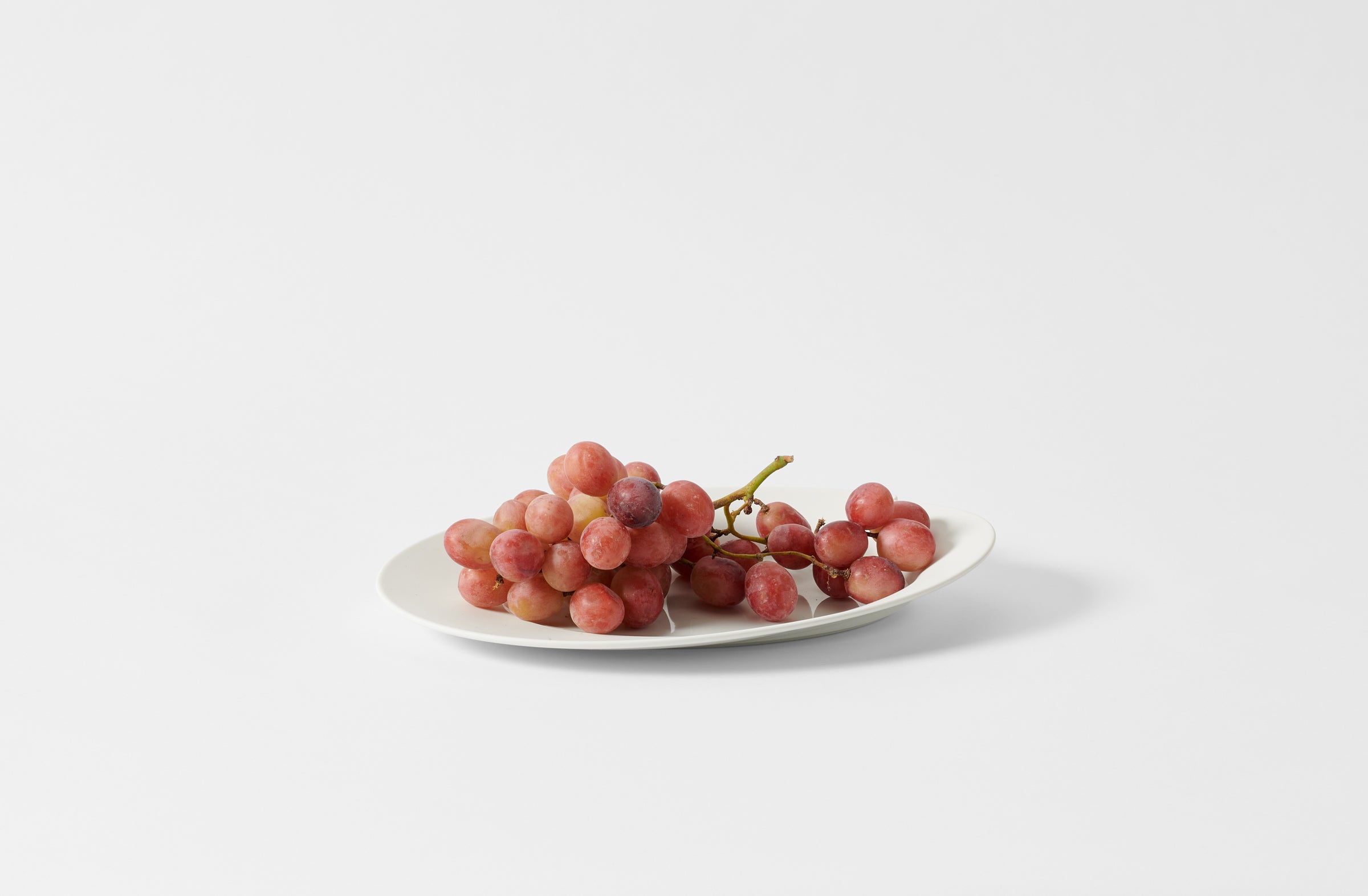 Hering Berlin white evolution oval dish holding grapes.