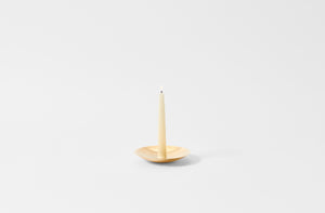 Ilse Crawford brass candle holder with lit candle