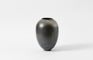 Karen Swami black smoke fired vessel with gold kintsugi.