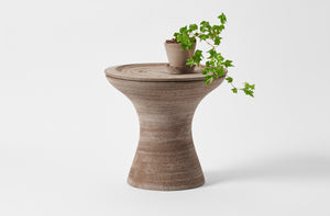 Large grey pedestal pot as table with planted ivy on top.