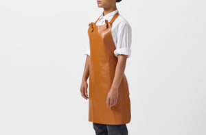 Model wearing Malle W. Trousseau tan leather apron.