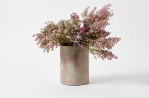 Michael Verheyden mixed concrete wide vase with pink wax flowers.