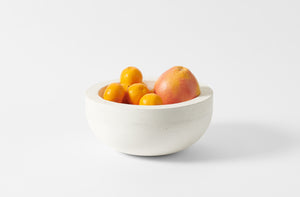 Michael Verheyden white concrete bowl holding citrus fruits.