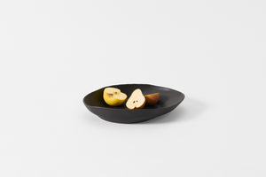 Molosco large matte black serving bowl with halved pears and apples.