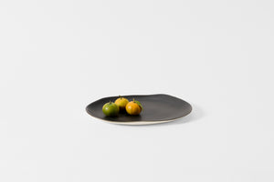 Molosco large matte black serving platter holding citrus.