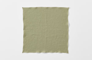 Moss linen napkin with natural rolled edge.