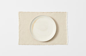 Natural fringed placemat with white Christiane Perrochon plate.