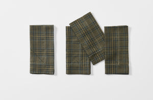 Four folded olive plaid linen Peter Speliopoulos hemstitch napkins.