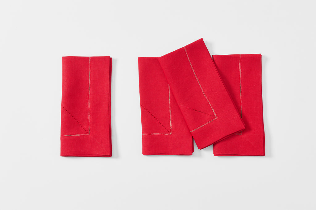 Four Peter Speliopoulos red hemstitch linen napkins folded.