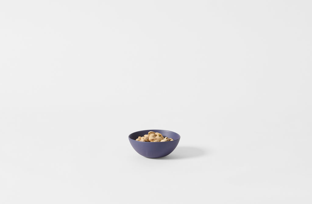 Extra small Rina Menardi blue shallow bowl with pistachios.