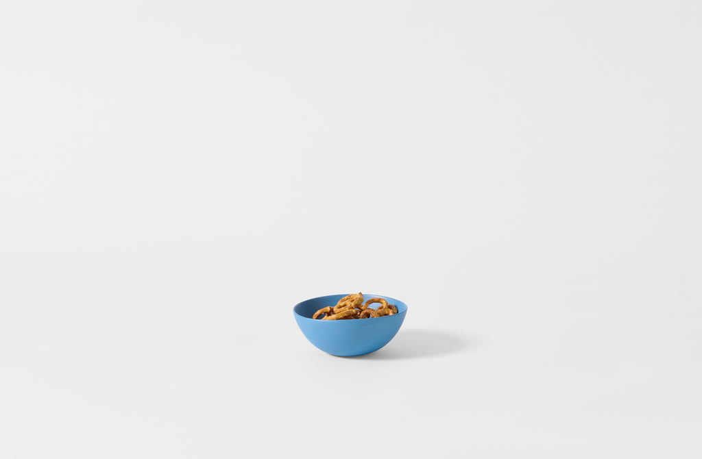 Extra small Rina Manardi turquoise shallow bowl holding pretzels.