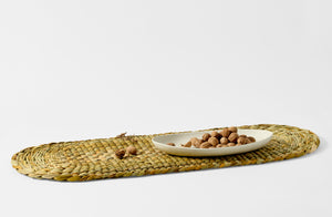 Rush Matters oval table mat with Christiane Perrochon bowl holding walnuts.