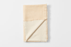 Straw and cream cashmere throw folded with detail of reverse.
