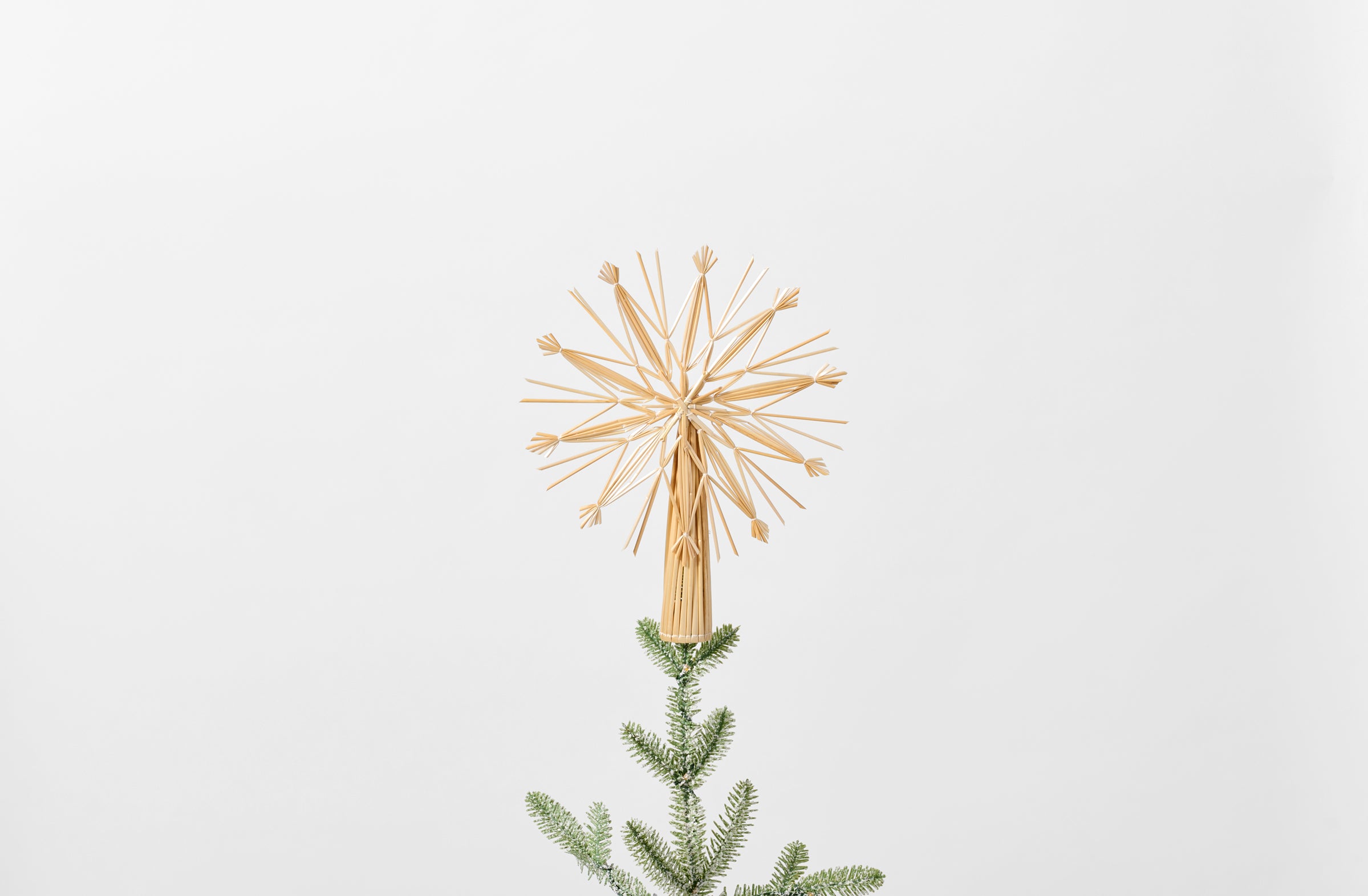 Straw snowflake tree topper on tree