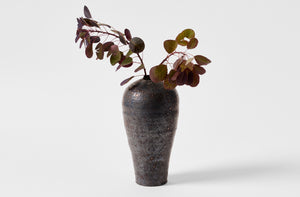 Takashi Endo large black vase with an arrangement of leaves.