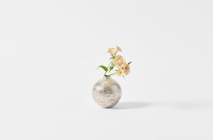 Takashi Endo tiny silver vase with a spray of petite peach flowers.