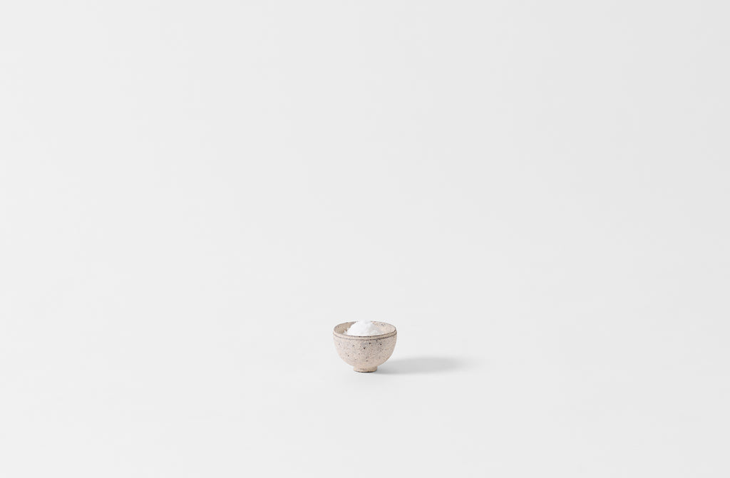 Takashi Endo petite white bowl holding flake sea salt.