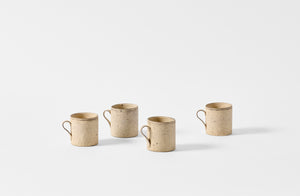 Four small white Takashi Endo mugs.