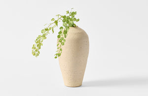 Takashi Endo tall white vase with greenery.