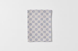 Folded Tori Murphy indigo tapestry kitchen towel.