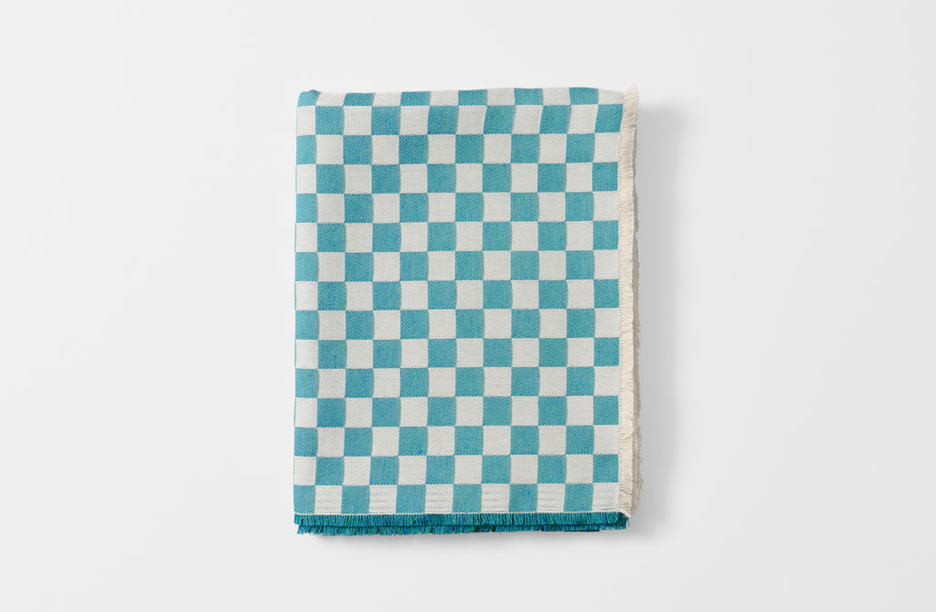Folded turquoise check tablecloth.