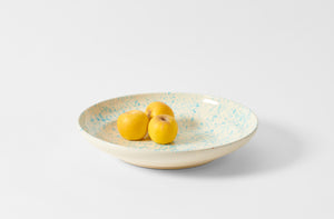 Turquoise and cream 17 inch splatterware platter holding golden apples.