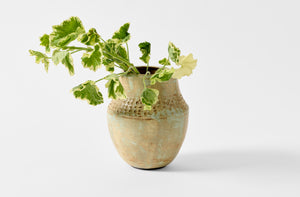 Victoria Morris carved pueblo vase with light geranium leaf arrangement.