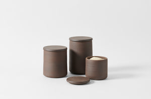 Trio of Victoria Morris brown clay canisters in small medium and large with small open and holding sugar.