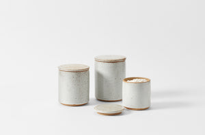 Trio of Victoria Morris white speckled canisters with small holding flour. Default