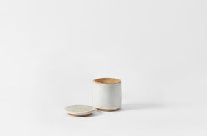 White ceramic container with lid on a white background