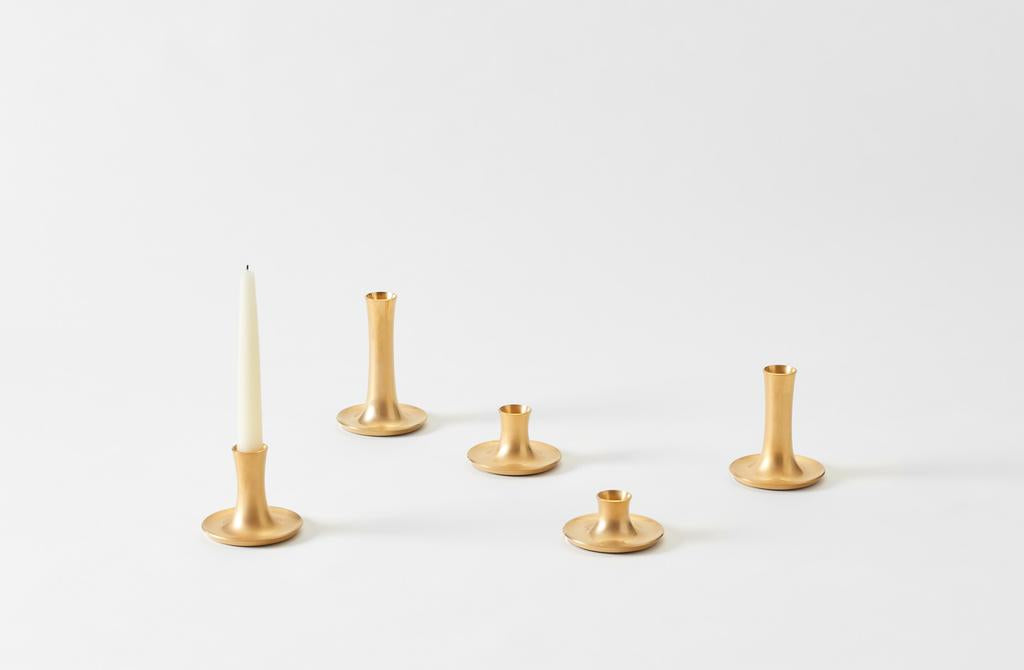 pumiced gold ted muehling fluted candlesticks in various sizes with one set with a single taper candle. Default